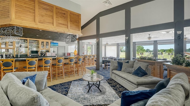 living room with a high ceiling, light tile patterned floors, and bar area