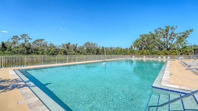 community pool with fence and view of scattered trees