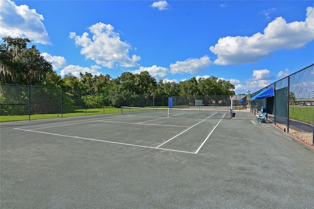 view of tennis court featuring fence