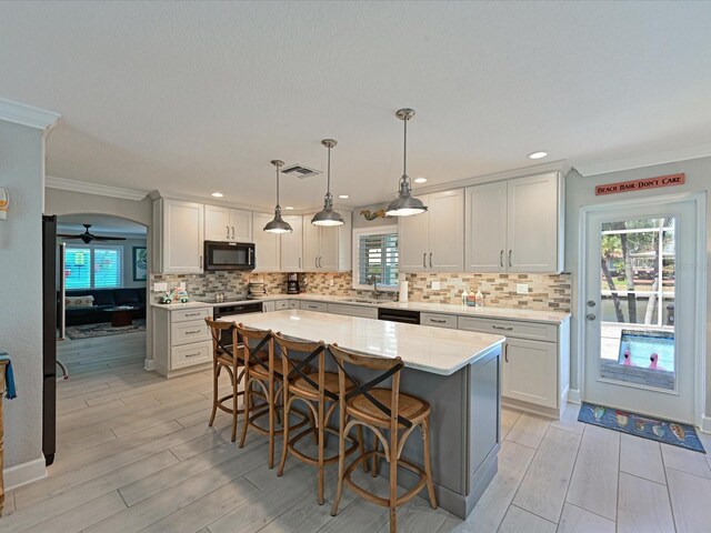 10016 Spoonbill Rd E, Bradenton, FL 34209 - kitchen featuring wood finish floors, a sink, backsplash, and black appliances
