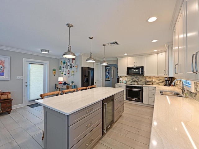 10016 Spoonbill Rd E, Bradenton, FL 34209 - kitchen with tasteful backsplash, visible vents, a sink, black appliances, and light stone countertops