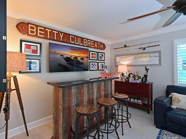 10016 Spoonbill Rd E, Bradenton, FL 34209 - bar featuring crown molding, a bar, ceiling fan, and wood finished floors