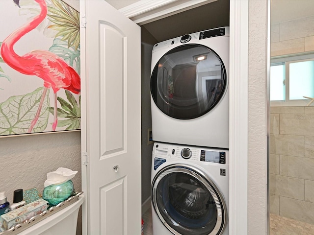 10016 Spoonbill Rd E, Bradenton, FL 34209 - clothes washing area featuring a textured wall, laundry area, and stacked washer / drying machine