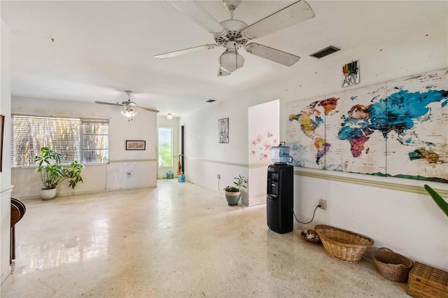 interior space with visible vents, ceiling fan, and speckled floor