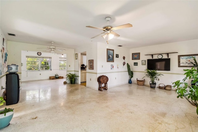 living room featuring visible vents, a ceiling fan, and speckled floor