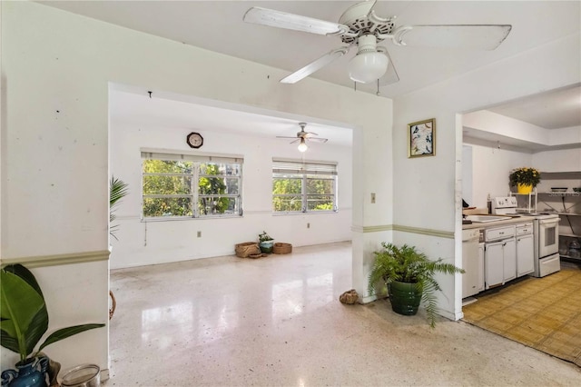 kitchen with ceiling fan, a sink, white appliances, light speckled floor, and white cabinetry