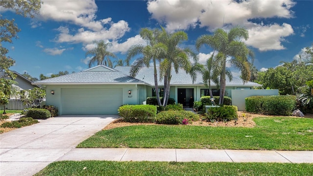 ranch-style home with a garage, stucco siding, and driveway