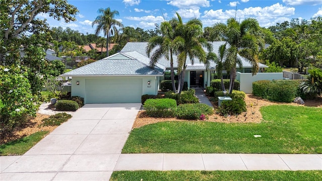 single story home featuring a garage, concrete driveway, and stucco siding