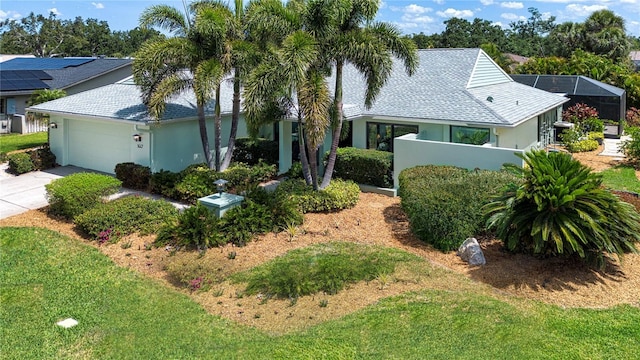 view of front of home with stucco siding, a garage, roof with shingles, concrete driveway, and a front yard