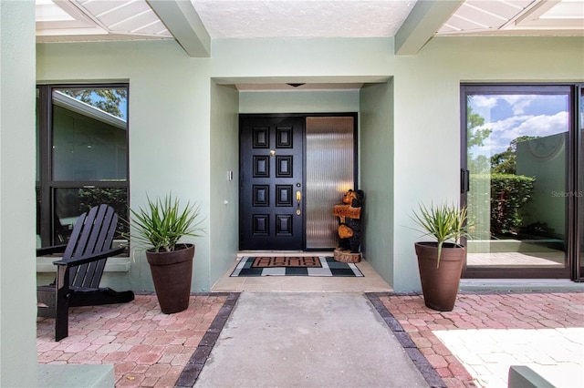 view of exterior entry with stucco siding