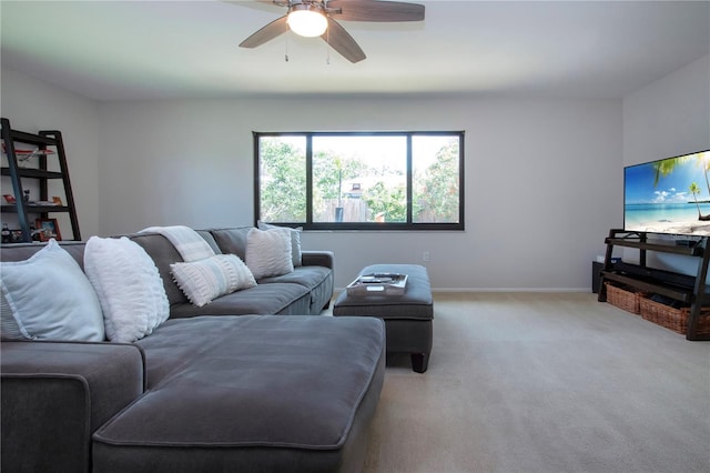 living area featuring light colored carpet, ceiling fan, and baseboards