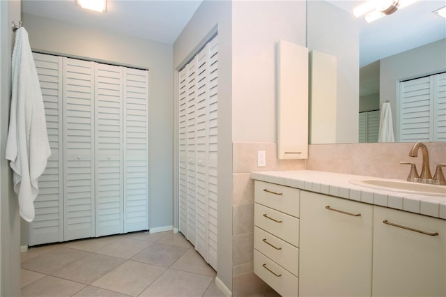 bathroom featuring tile patterned floors, vanity, and a closet