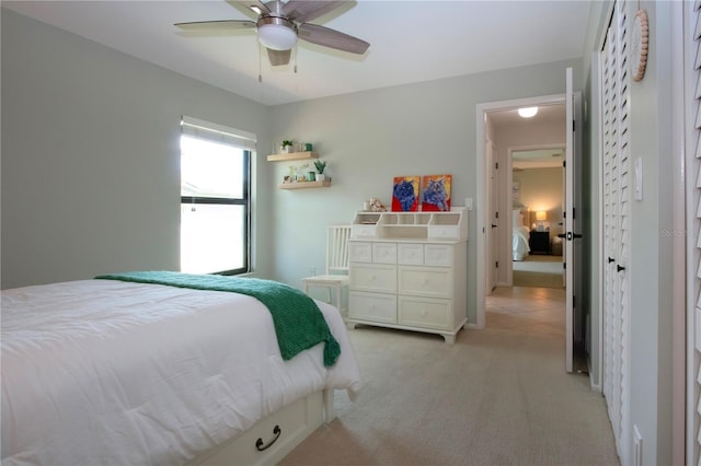 bedroom with light carpet and a ceiling fan