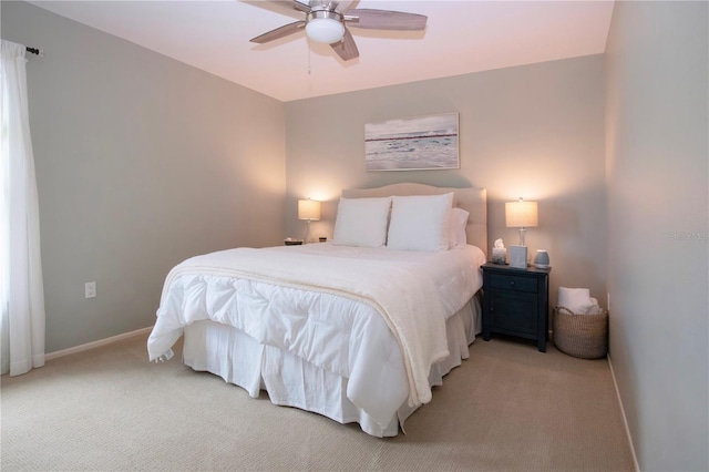 bedroom featuring light carpet, baseboards, and a ceiling fan