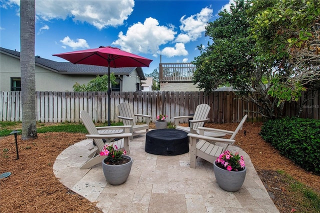 view of patio featuring an outdoor fire pit and fence