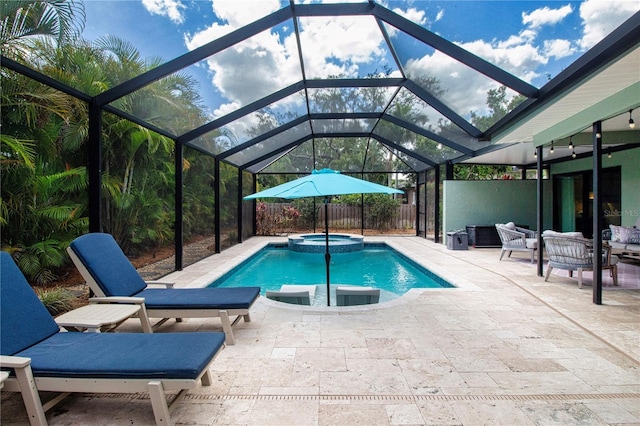 view of swimming pool featuring a patio area, a pool with connected hot tub, and a lanai