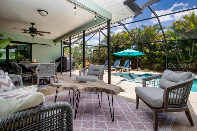 view of patio / terrace featuring ceiling fan, outdoor dining area, a lanai, and an outdoor pool