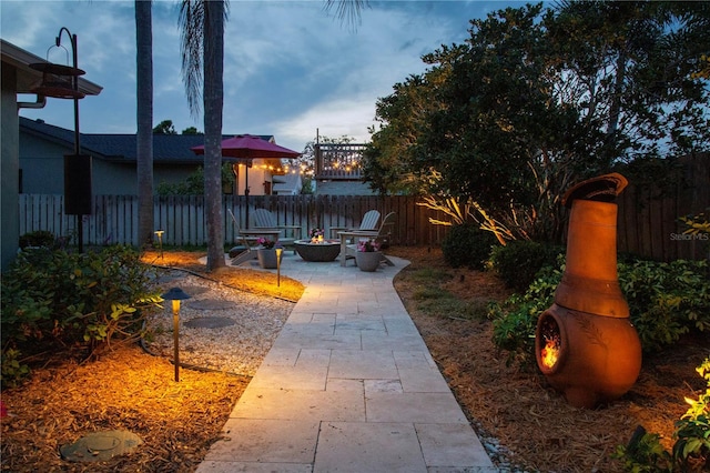 view of yard featuring a fire pit, fence, and a patio