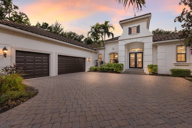7532 Greystone St, Lakewood Ranch, FL 34202 - view of front of home featuring french doors, decorative driveway, a tile roof, an attached garage, and stucco siding