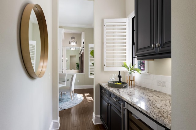 7532 Greystone St, Lakewood Ranch, FL 34202 - kitchen with dark wood-style floors, dark cabinetry, light stone countertops, wine cooler, and baseboards