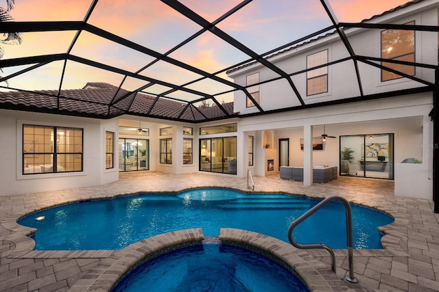 7532 Greystone St, Lakewood Ranch, FL 34202 - pool at dusk featuring ceiling fan, a patio, a pool with connected hot tub, an outdoor living space, and glass enclosure