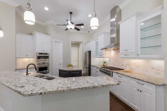 7532 Greystone St, Lakewood Ranch, FL 34202 - kitchen featuring wall chimney exhaust hood, stainless steel appliances, a kitchen island, crown molding, and a ceiling fan