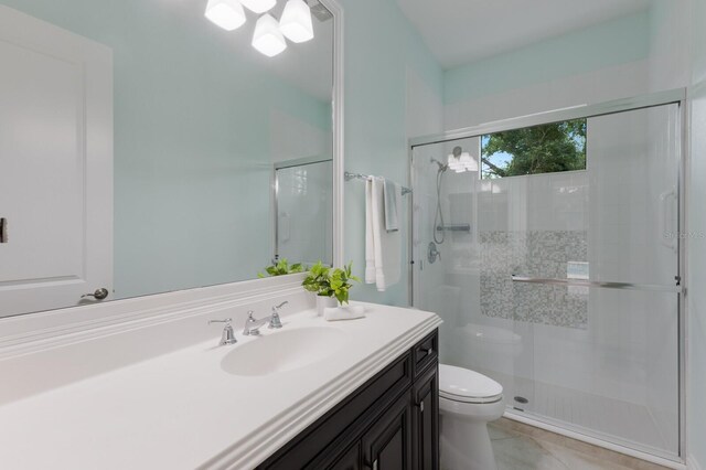 7532 Greystone St, Lakewood Ranch, FL 34202 - bathroom featuring toilet, vanity, a shower stall, and tile patterned flooring