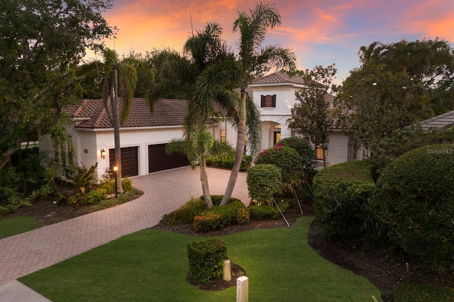 7532 Greystone St, Lakewood Ranch, FL 34202 - mediterranean / spanish home featuring decorative driveway, a garage, stucco siding, a tiled roof, and a yard