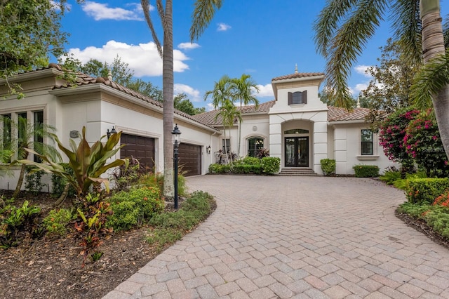 7532 Greystone St, Lakewood Ranch, FL 34202 - mediterranean / spanish house with french doors, an attached garage, a tile roof, stucco siding, and decorative driveway