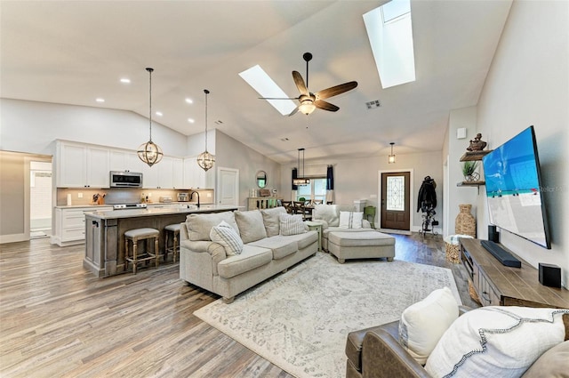 1103 134th St E, Bradenton, FL 34212 - living area with a skylight, light wood-style flooring, ceiling fan, high vaulted ceiling, and recessed lighting