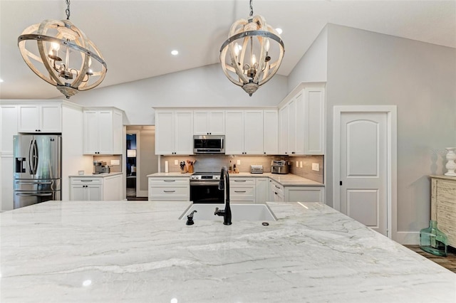 1103 134th St E, Bradenton, FL 34212 - kitchen featuring a chandelier, stainless steel appliances, a sink, light stone countertops, and high vaulted ceiling