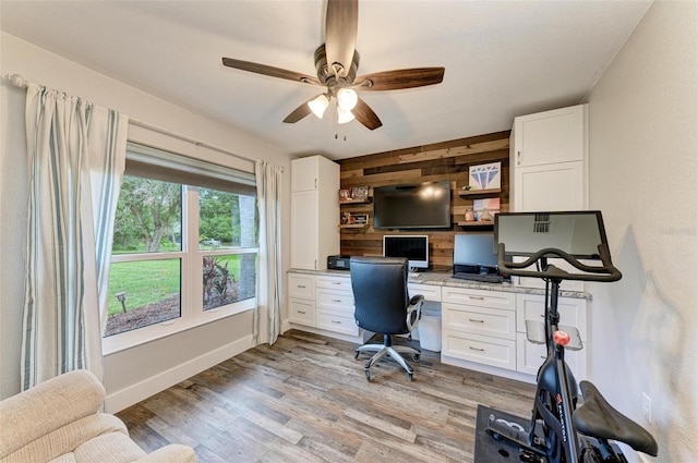 1103 134th St E, Bradenton, FL 34212 - home office featuring wooden walls, built in desk, a ceiling fan, light wood-type flooring, and baseboards