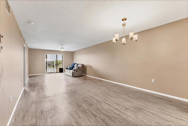 interior space featuring visible vents, baseboards, wood finished floors, and ceiling fan with notable chandelier