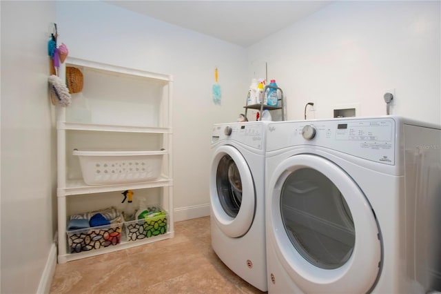clothes washing area with independent washer and dryer, laundry area, and baseboards
