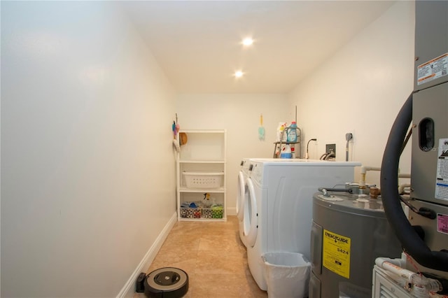 clothes washing area featuring laundry area, recessed lighting, water heater, washer and dryer, and baseboards