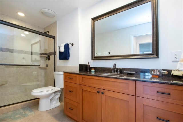 full bathroom with tile patterned floors, vanity, a stall shower, and toilet