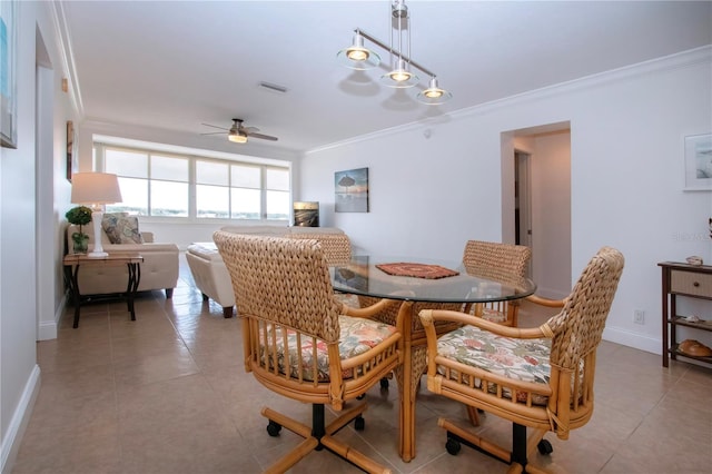 dining space with crown molding, ceiling fan, light tile patterned flooring, and baseboards