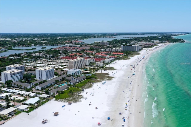 birds eye view of property with a water view, a beach view, and a city view
