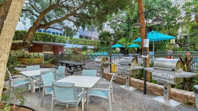 view of patio / terrace with outdoor dining space, a grill, and fence
