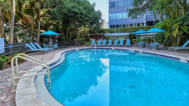pool with a patio and fence