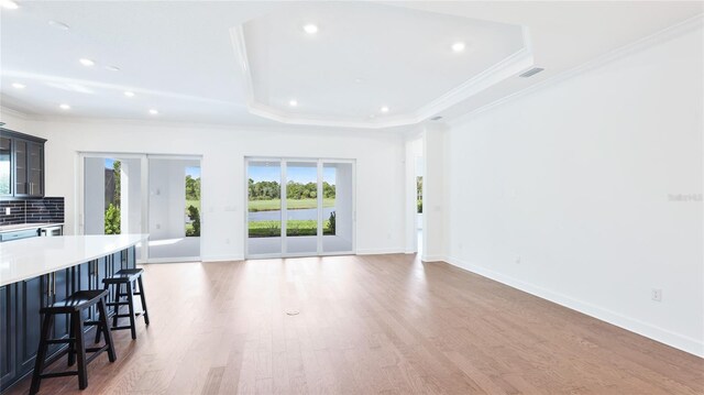 15722 San Lazzaro Ave, Lakewood Ranch, FL 34211 - living room featuring light wood finished floors, baseboards, ornamental molding, and a raised ceiling