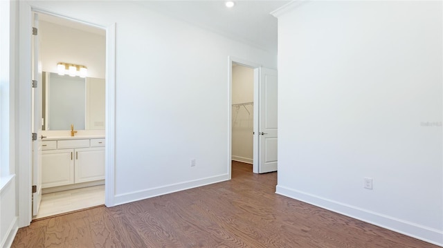 15722 San Lazzaro Ave, Lakewood Ranch, FL 34211 - unfurnished bedroom featuring wood finished floors, ensuite bathroom, baseboards, and a spacious closet