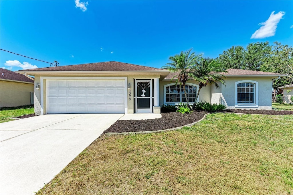 1323 Arredondo St, North Port, FL 34286 - ranch-style house featuring an attached garage, a front lawn, driveway, and stucco siding