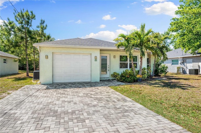2840 S Shade Ave, Sarasota, FL 34239 - ranch-style home with an attached garage, cooling unit, decorative driveway, and stucco siding