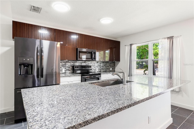 2840 S Shade Ave, Sarasota, FL 34239 - kitchen featuring visible vents, baseboards, a sink, stainless steel appliances, and decorative backsplash
