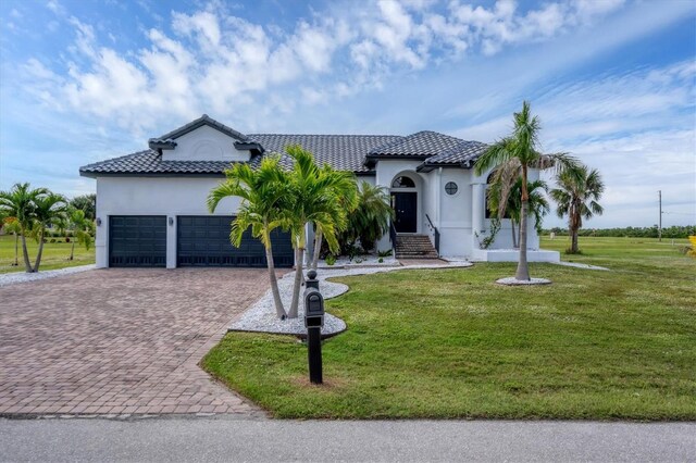 24017 Peppercorn Rd, Punta Gorda, FL 33955 - view of front facade featuring a front yard, a garage, a tile roof, stucco siding, and decorative driveway