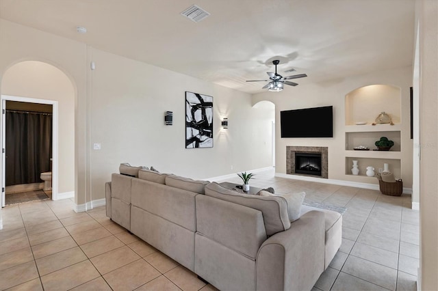 24017 Peppercorn Rd, Punta Gorda, FL 33955 - living area with a ceiling fan, arched walkways, light tile patterned floors, and built in shelves
