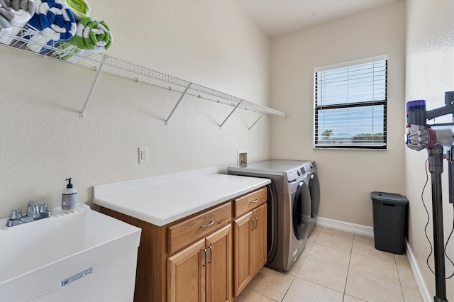 24017 Peppercorn Rd, Punta Gorda, FL 33955 - laundry area with separate washer and dryer, baseboards, light tile patterned floors, cabinet space, and a sink