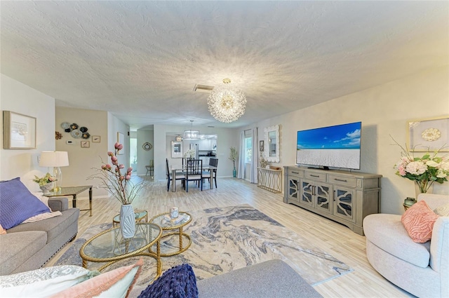 1622 Stafford Ln Unit 1205, Sarasota, FL 34232 - living room featuring wood finished floors, visible vents, and an inviting chandelier