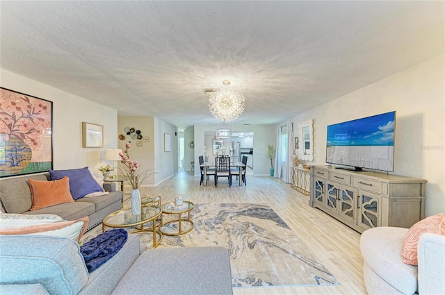 1622 Stafford Ln Unit 1205, Sarasota, FL 34232 - living area with a chandelier, light wood-type flooring, and a textured ceiling